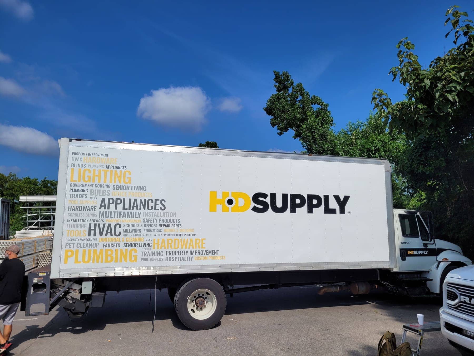 White HD Supply box truck with a word-collage design listing building trades on the box side
