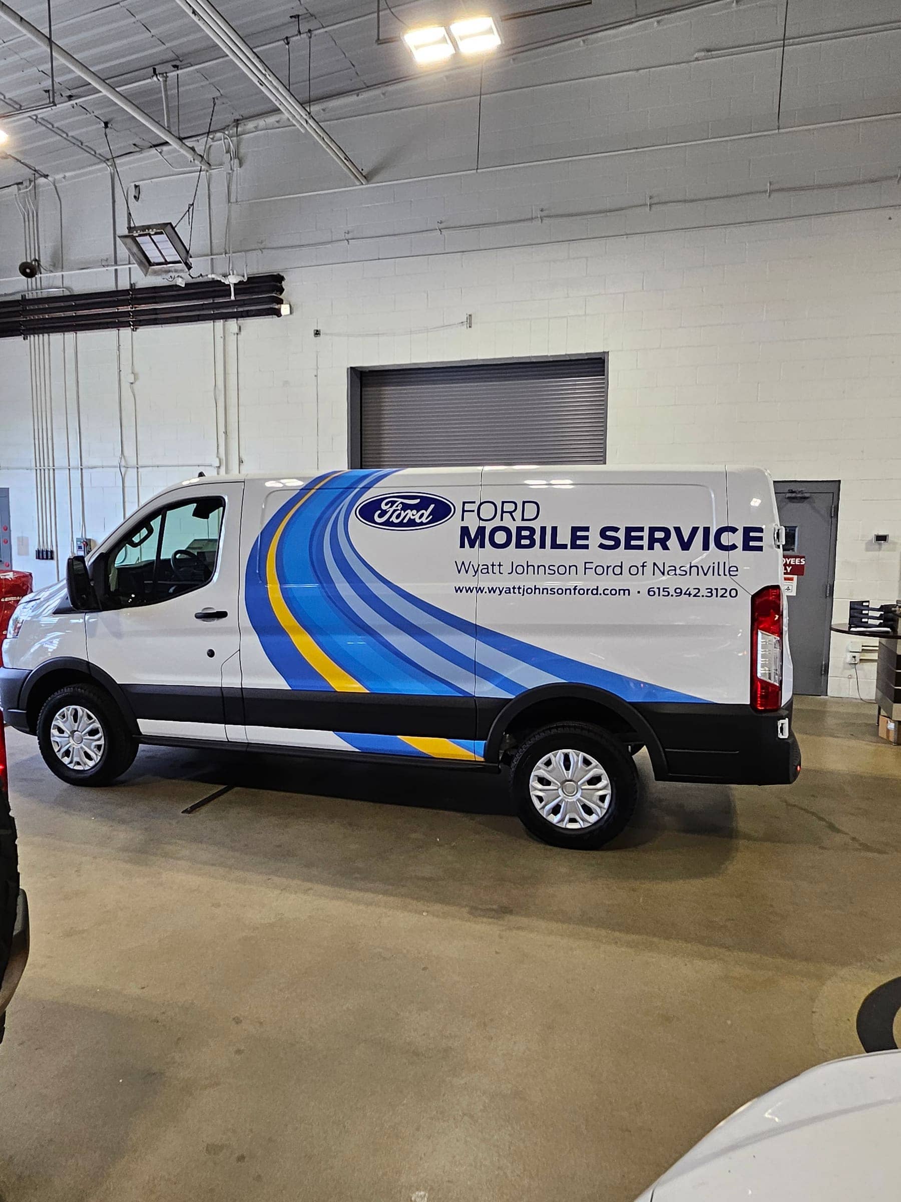 Ford Transit mobile service van with blue and yellow swoosh graphics for Wyatt Johnson Ford