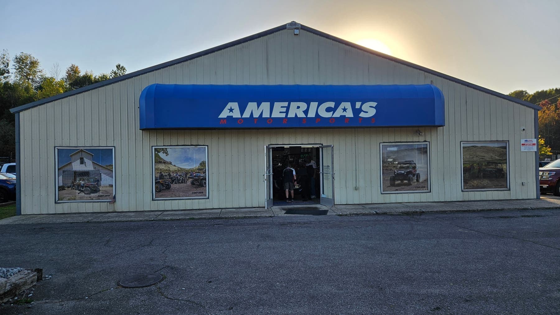 Blue awning storefront with printed motorsports graphics across the front windows