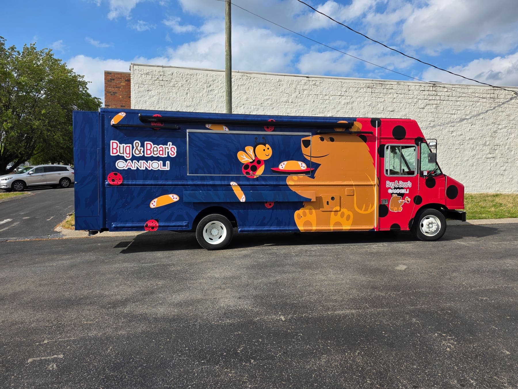 Navy and orange Bug and Bear's Cannoli food truck with an illustrated bear, ladybug, and cannoli