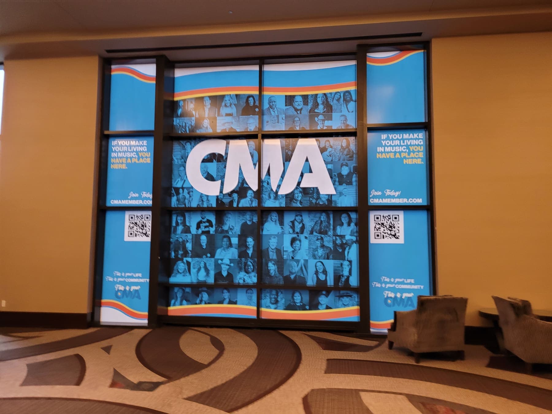 CMA office windows with a photo-grid membership display and QR call to action