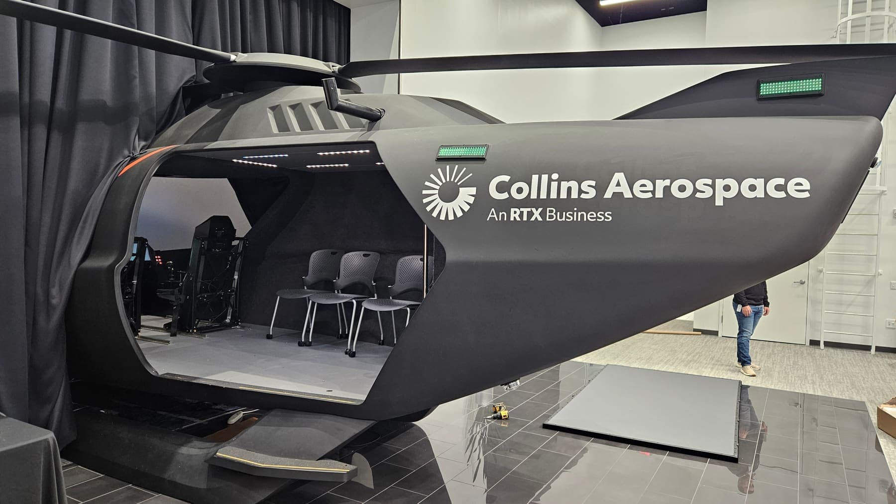 Collins Aerospace lettering applied to a gray helicopter training simulator shell