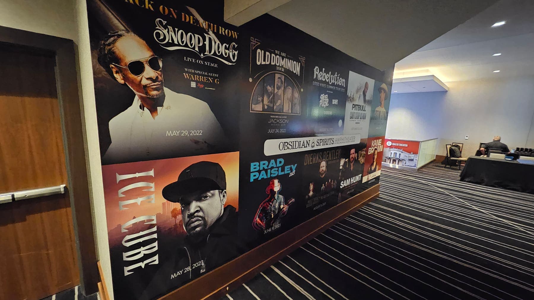 Venue hallway wall covered in a collage of printed concert poster graphics