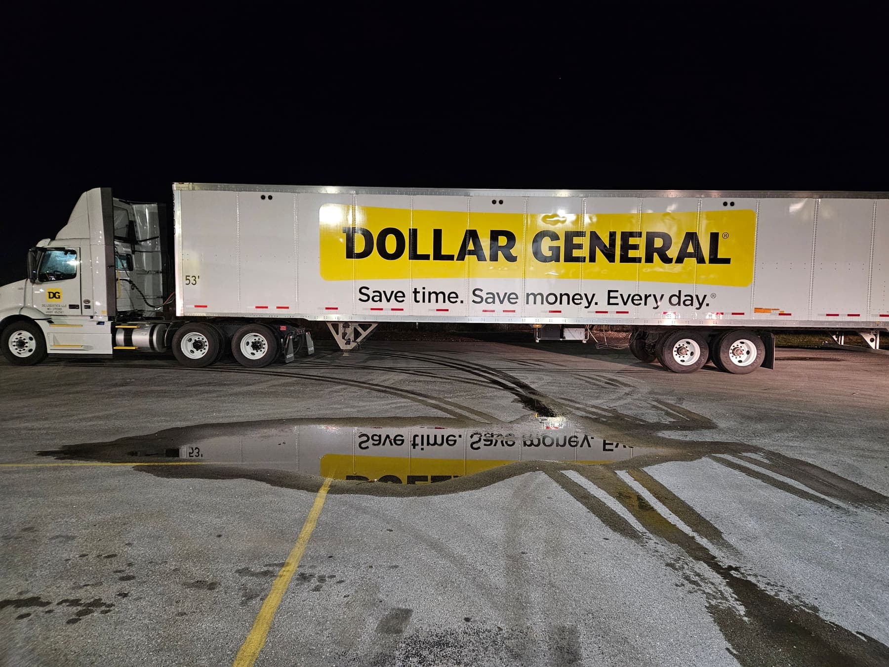 Dollar General semi-trailer with yellow and black Save time Save money graphics at night