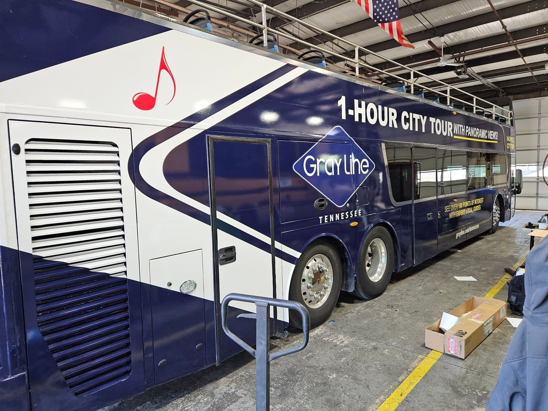 Navy double-decker bus in a full Nashville City Tour wrap with music-note graphics