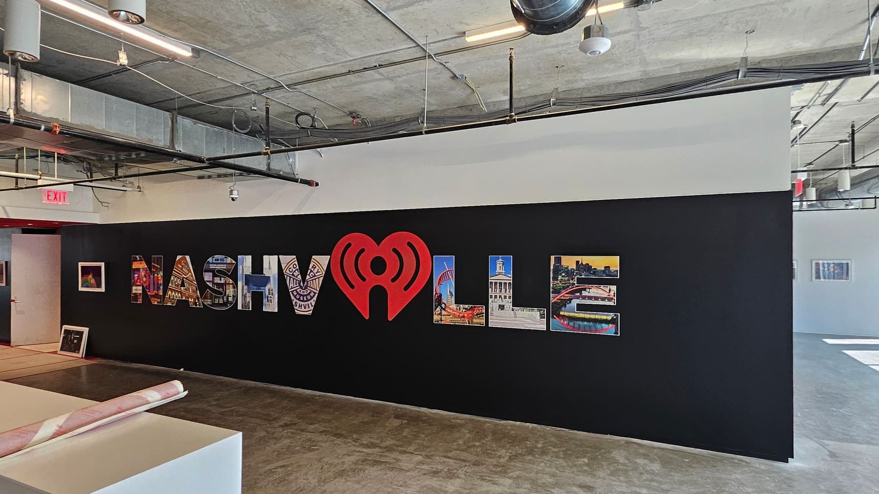 Black feature wall spelling Nashville with photo-filled letters and a red iHeart logo