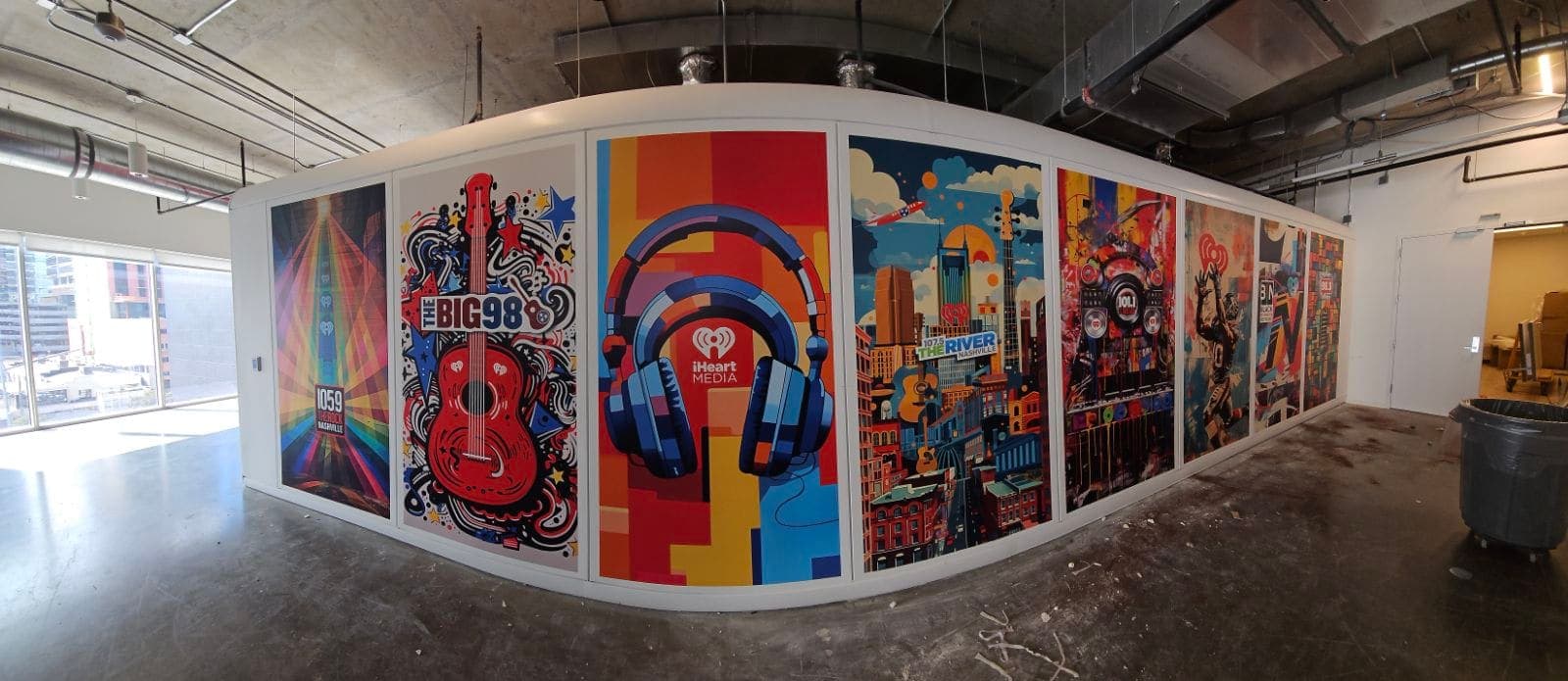 Curved office wall with colorful Nashville-skyline and guitar artwork panels