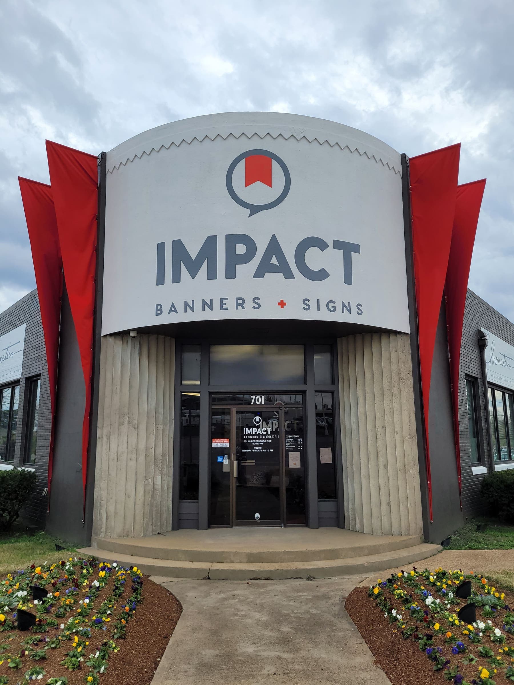 Impact Banners and Signs dimensional storefront sign with red accent fins on concrete