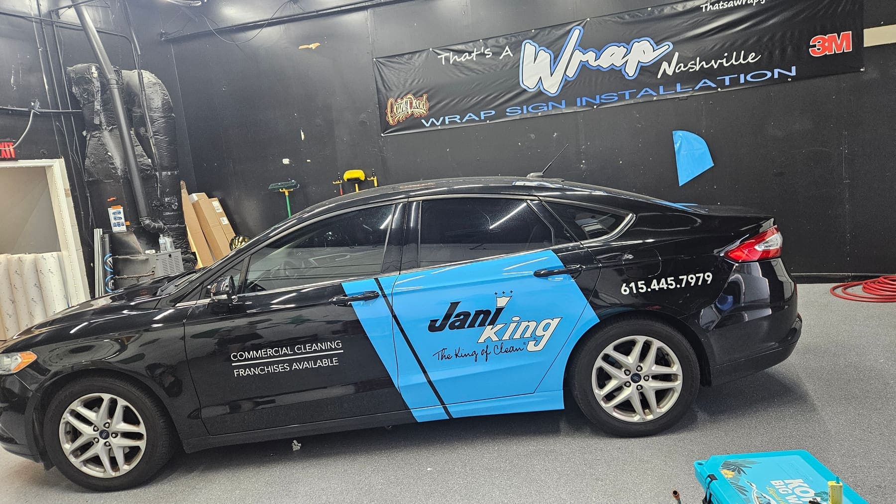 Partially wrapped Ford Fusion inside the That's a Wrap shop