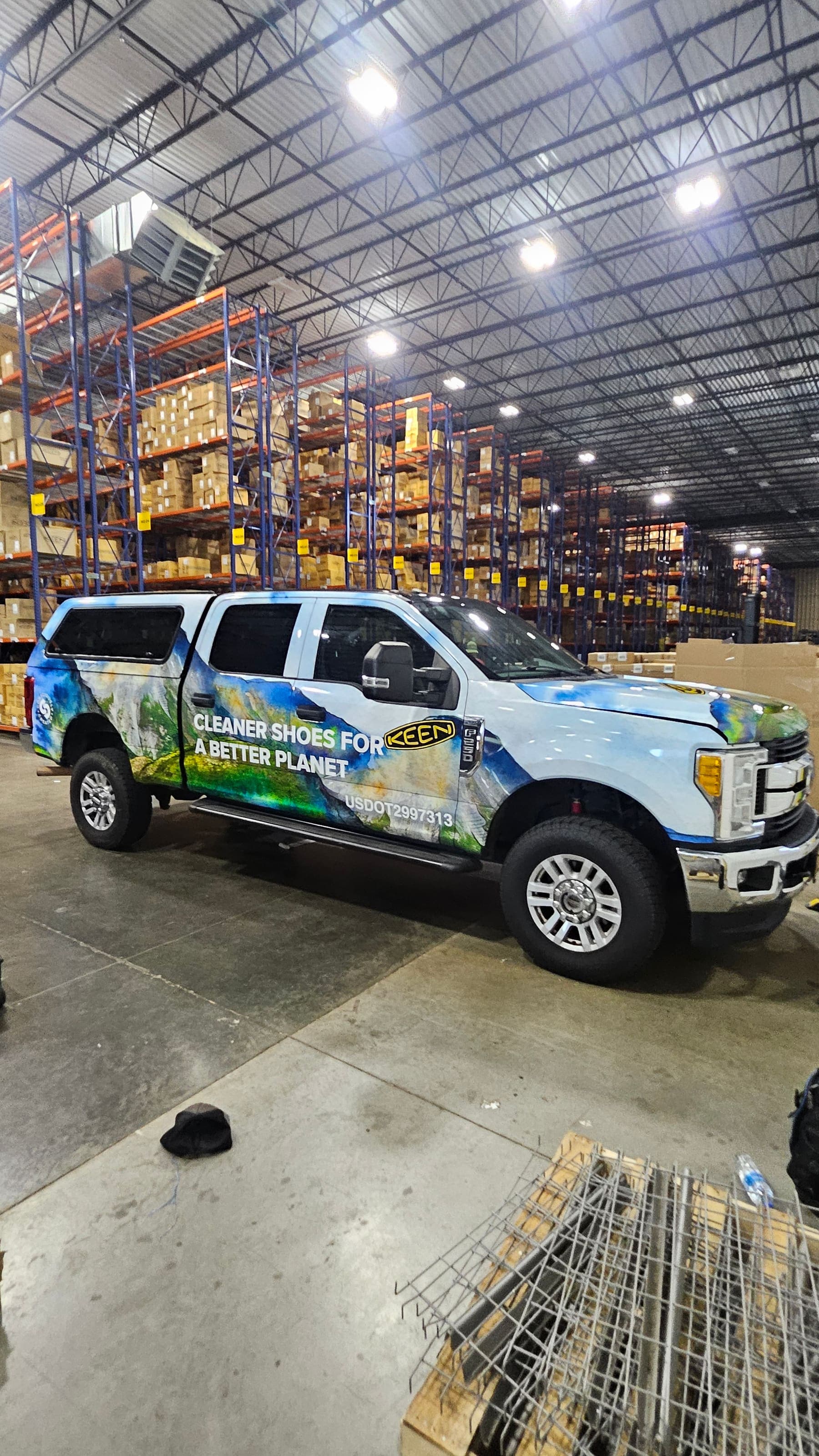 KEEN F-250 in a warehouse aisle showing the wrap across the front and driver side