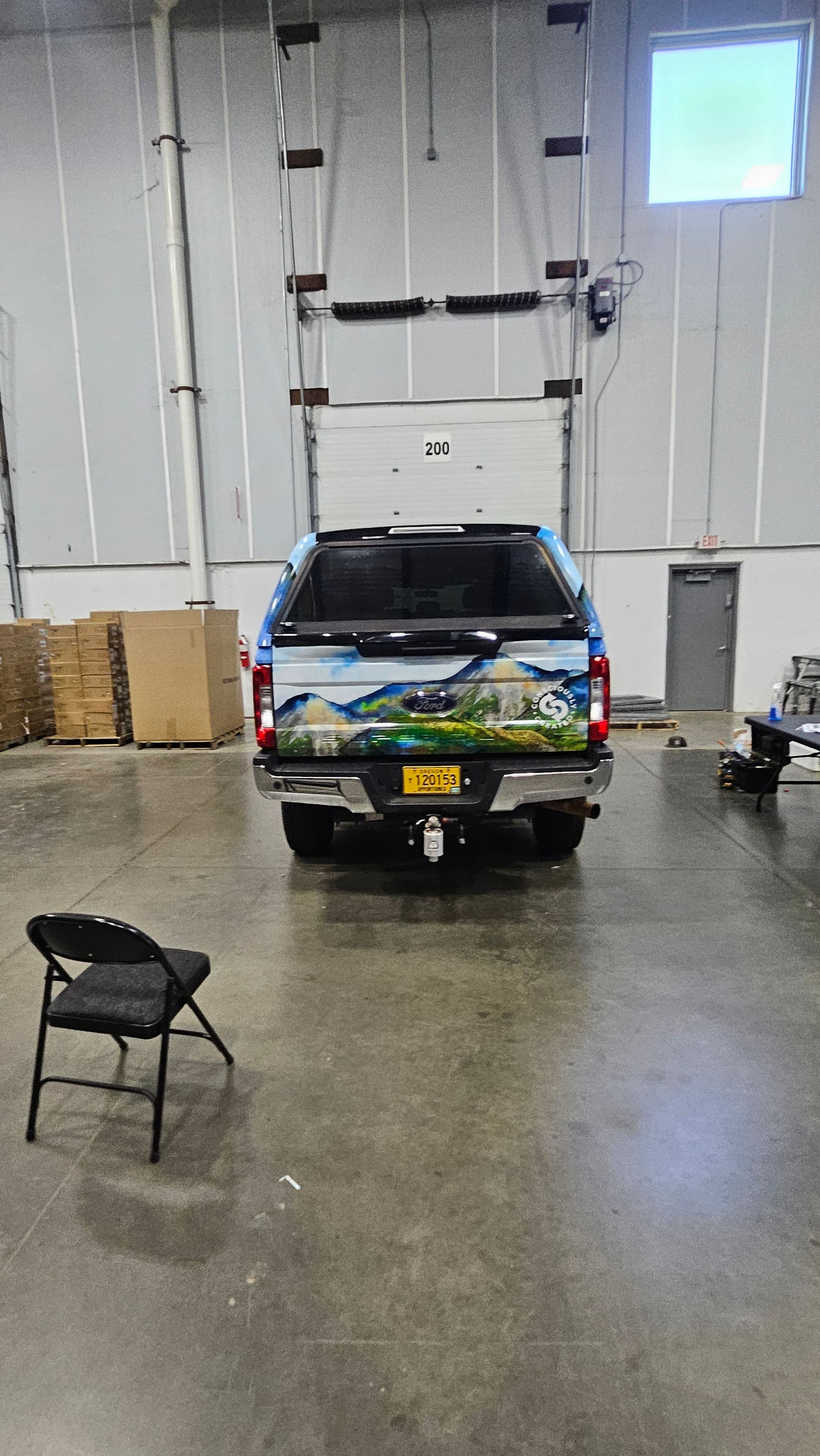 Rear view of the wrapped tailgate and camper shell in a warehouse
