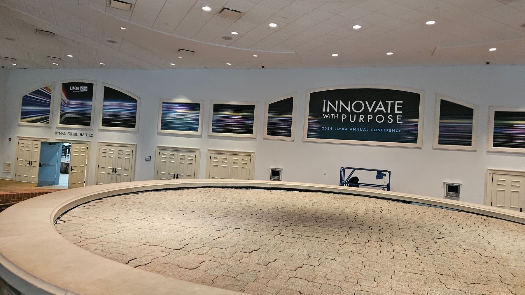 Curved venue windows carrying Innovate With Purpose conference banner graphics