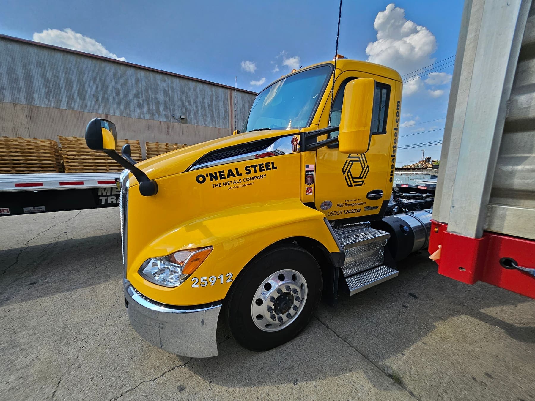 Yellow Kenworth semi tractor with black O'Neal Steel door lettering