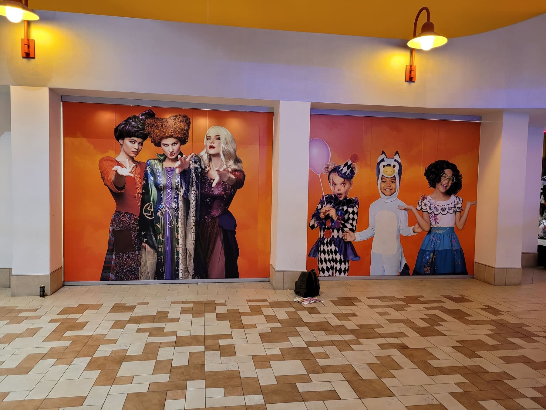 Mall storefront covered in orange Spirit Halloween window graphics